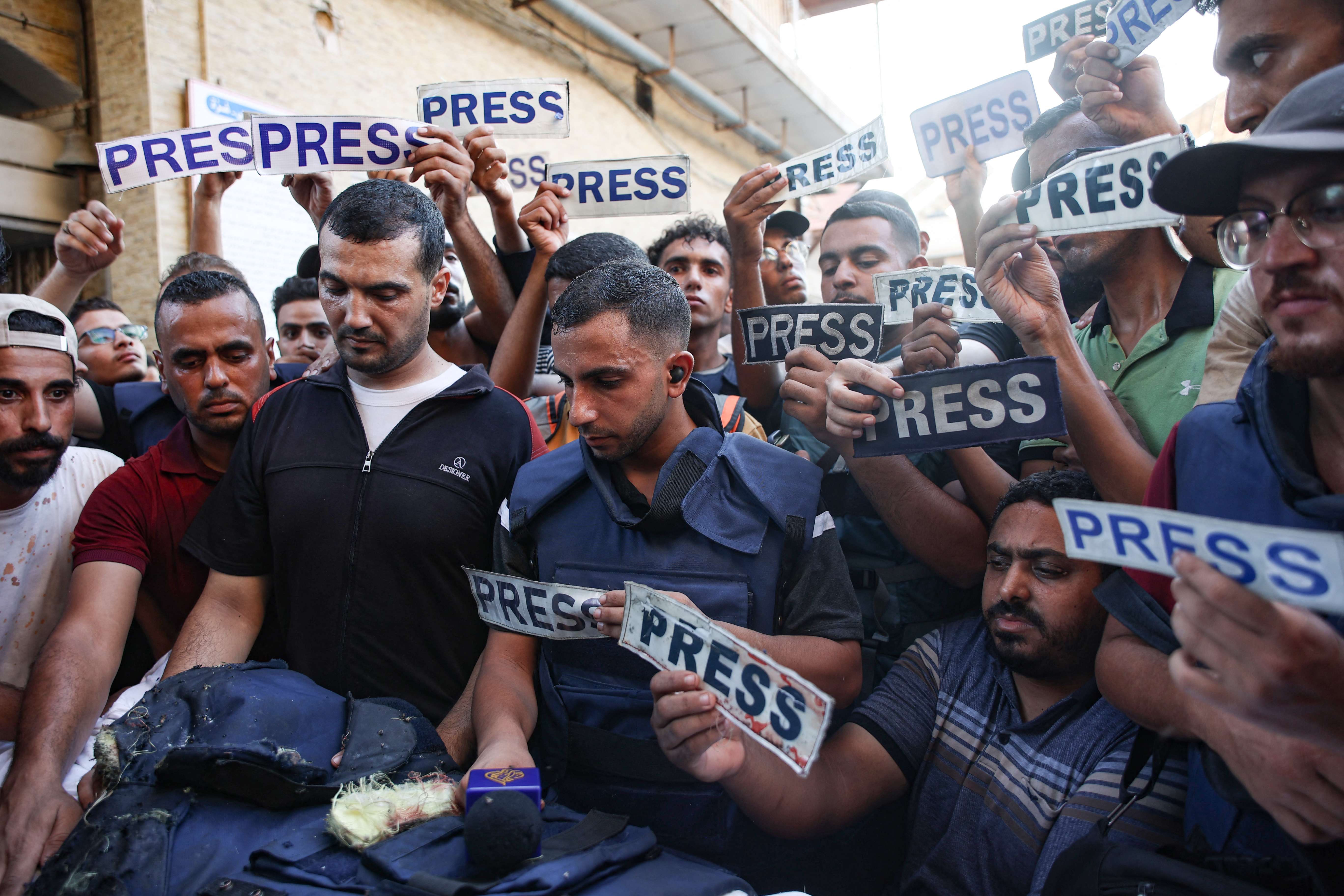 Mourners and colleagues holding 'press' signs surround the body of Al-Jazeera Arabic journalist Ismail al-Ghoul, killed along with his cameraman Rami al-Refee in an Israeli strike during their coverage of Gaza's Al-Shati refugee camp, on July 31, 2024. (File photo/AFP)