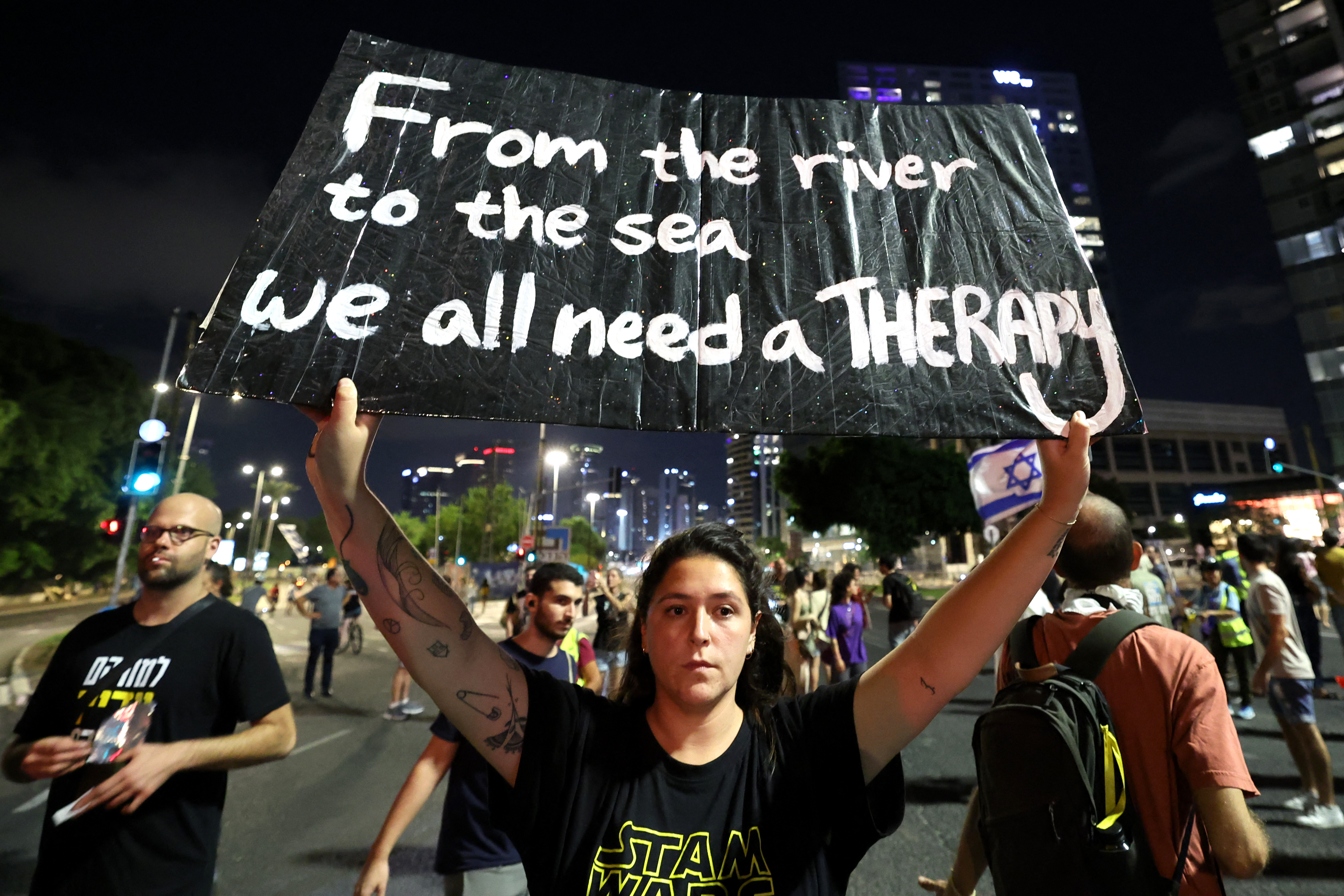 A demonstrator holds a placard during an anti-government protest calling for action to secure the release of Israeli hostages in front of the Israeli Defense Ministry in Tel Aviv on September 21, 2024. (AFP)