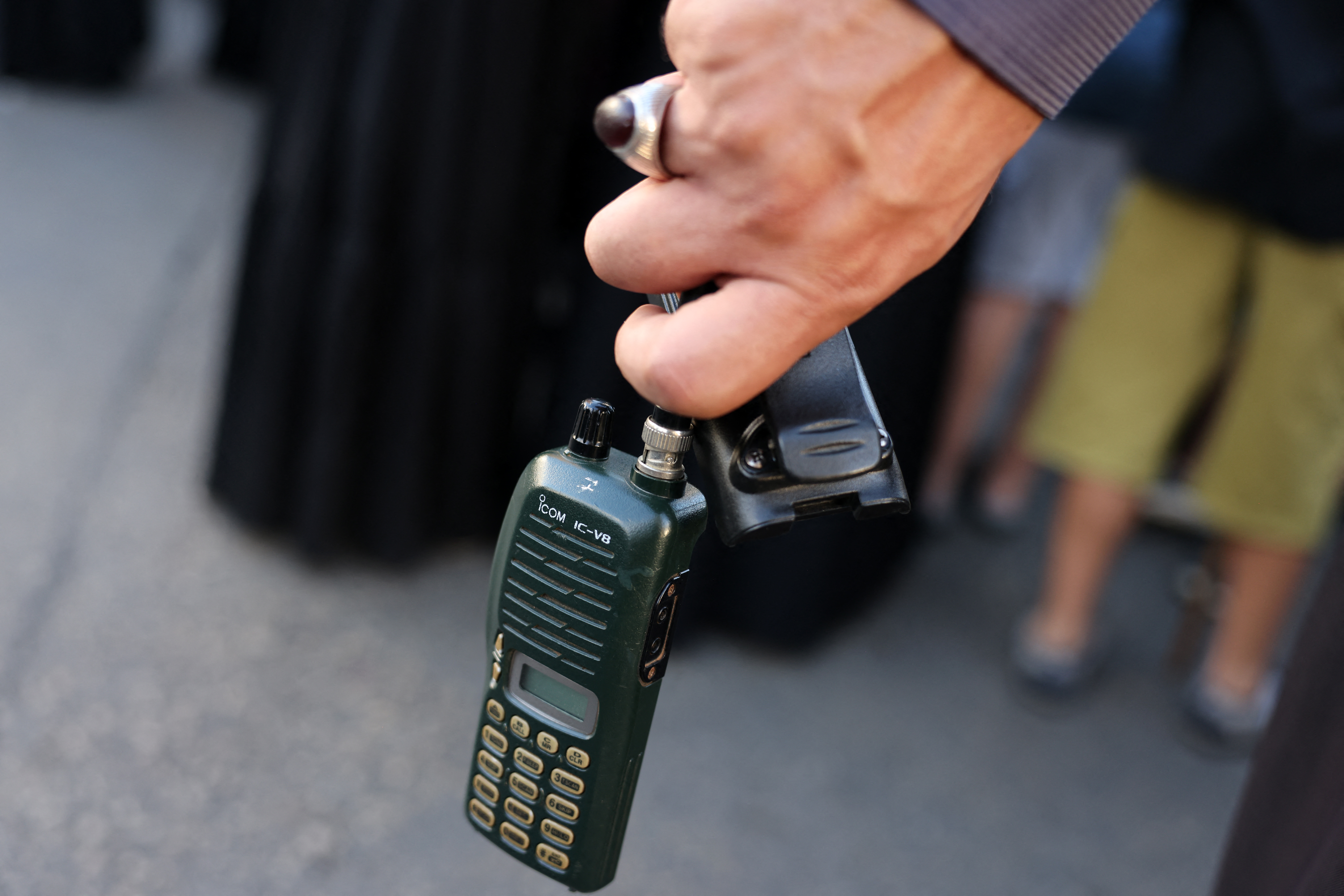 A man holds an Icom walkie talkie device after he removed the battery during the funeral of persons killed when hundreds of paging devices exploded in a deadly wave across Lebanon on September 17 and 18 blamed on Israel. (AFP)