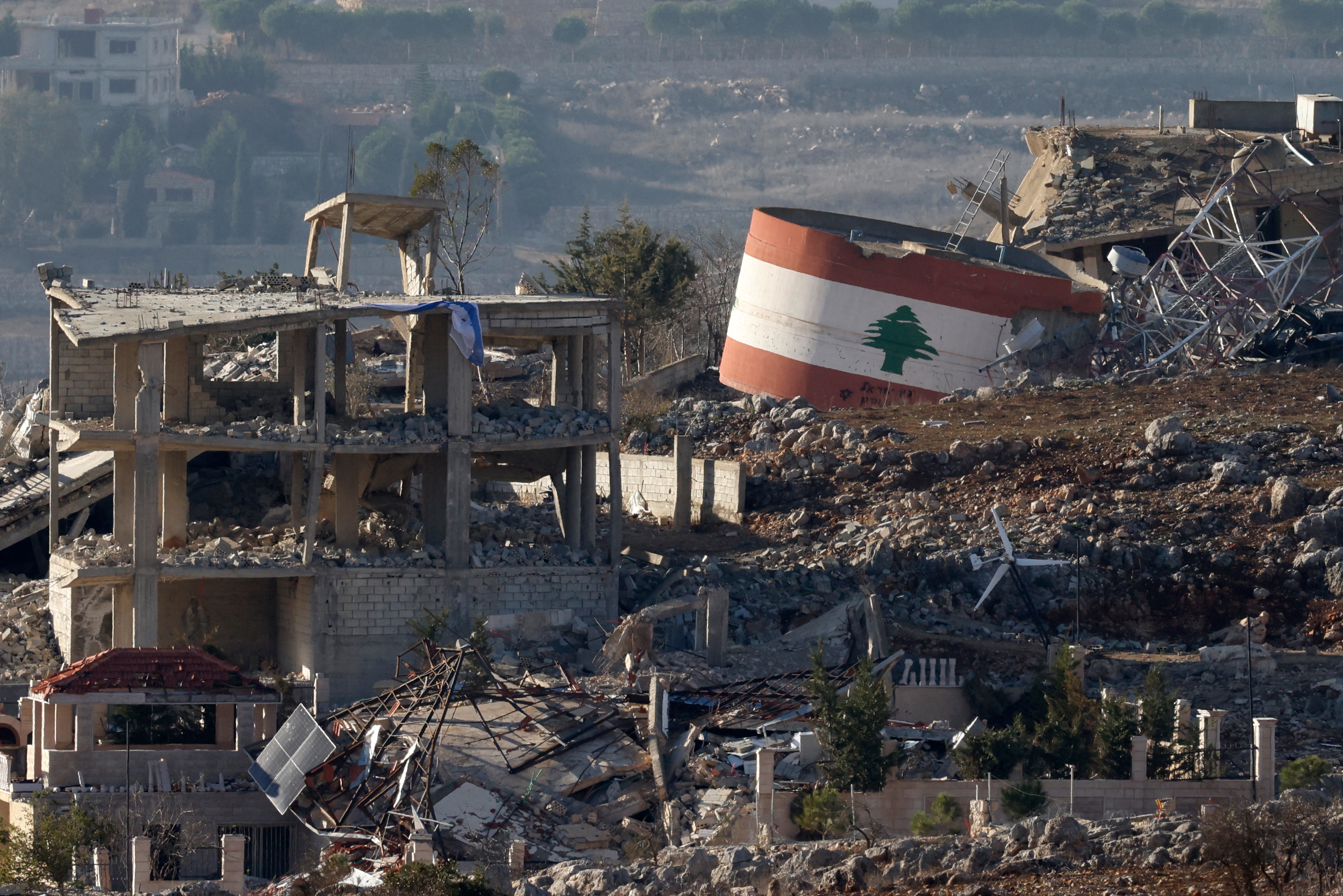 A downed Israeli flag (left) on a destroyed building, and a Lebanese flag (right) painted on a damaged building in the southern Lebanese village of Meiss El-Jabal, amid the ongoing war between Israel and Hezbollah. (AFP)